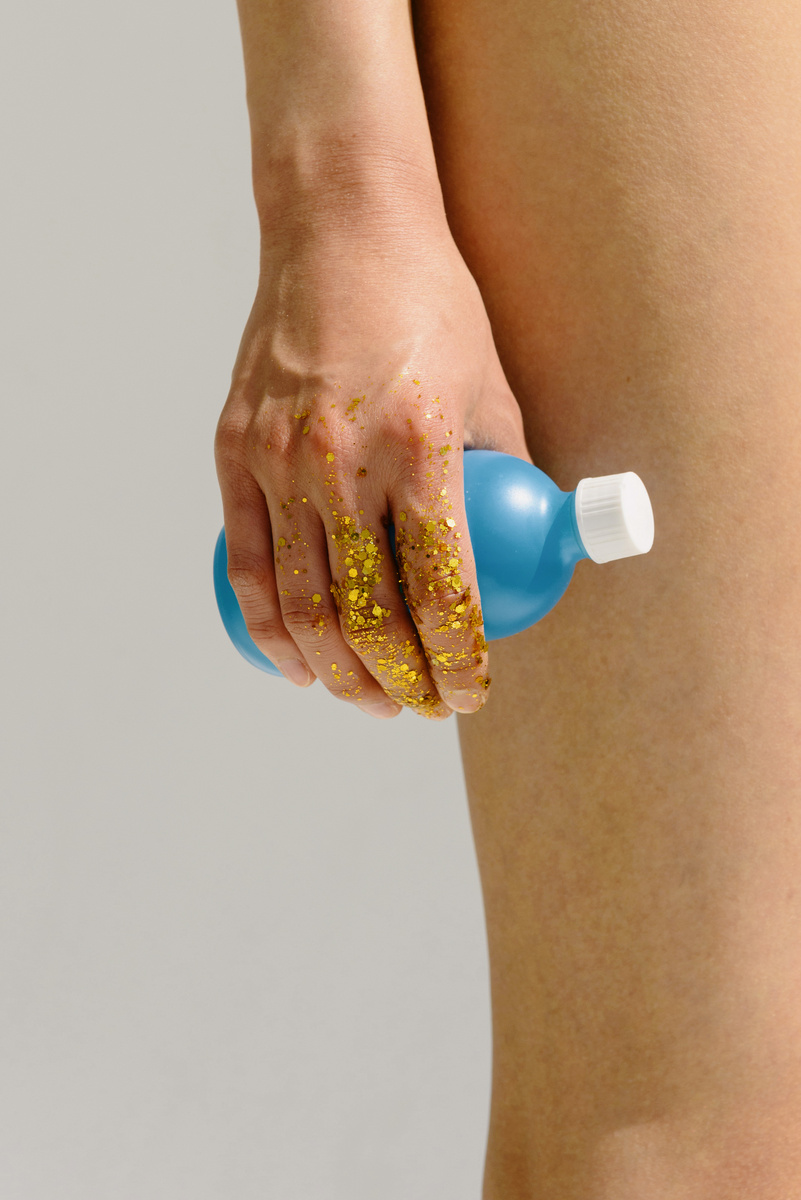 Person Holding Blue and White Plastic Bottle