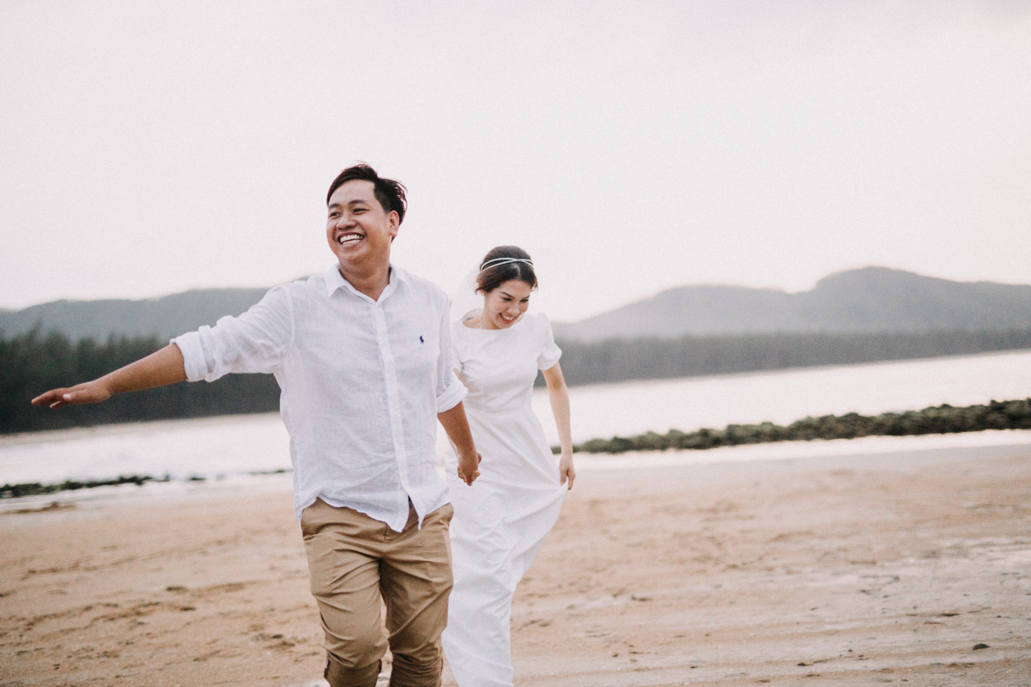 Man in White Dress Shirt and Brown Pants Standing on Brown Sand