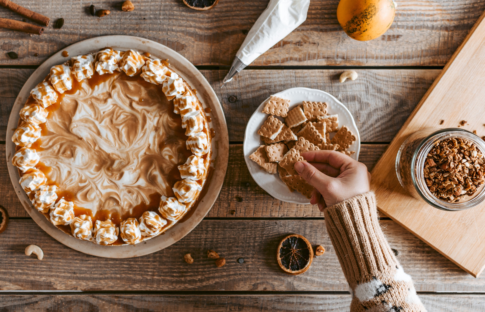 Crop unrecognizable woman taking cookie served on table near pie